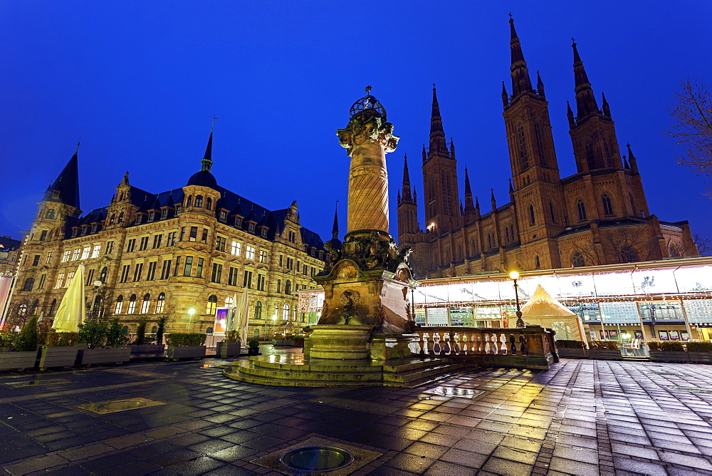 Monument on illuminated square, Germany, Hesse, Wiesbaden, Rathaus and Marktkirche