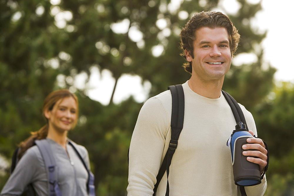 Couple wearing backpacks in woods