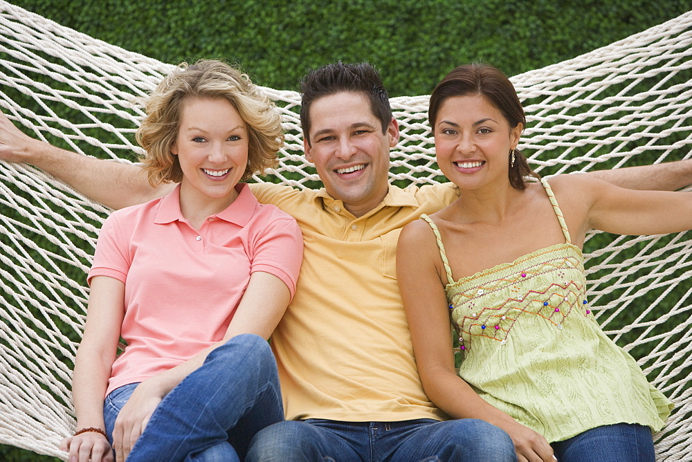 Multi-ethnic friends sitting on hammock