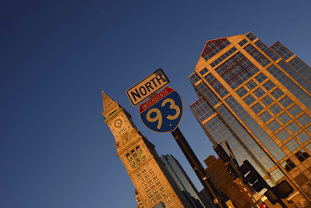 Road sign and office buildings at sunrise, USA, Massachusetts, Boston