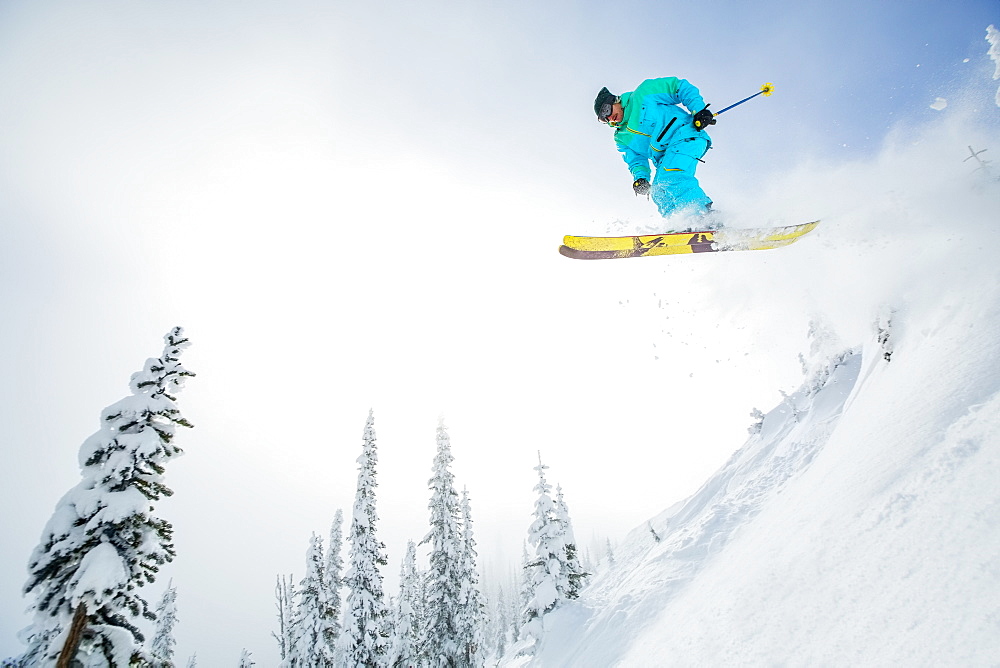 Young man jumping from ski slope, USA, Montana, Whitefish