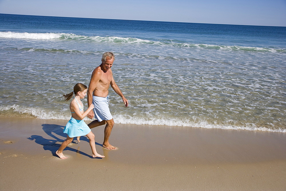 Father and daughter walking on beach