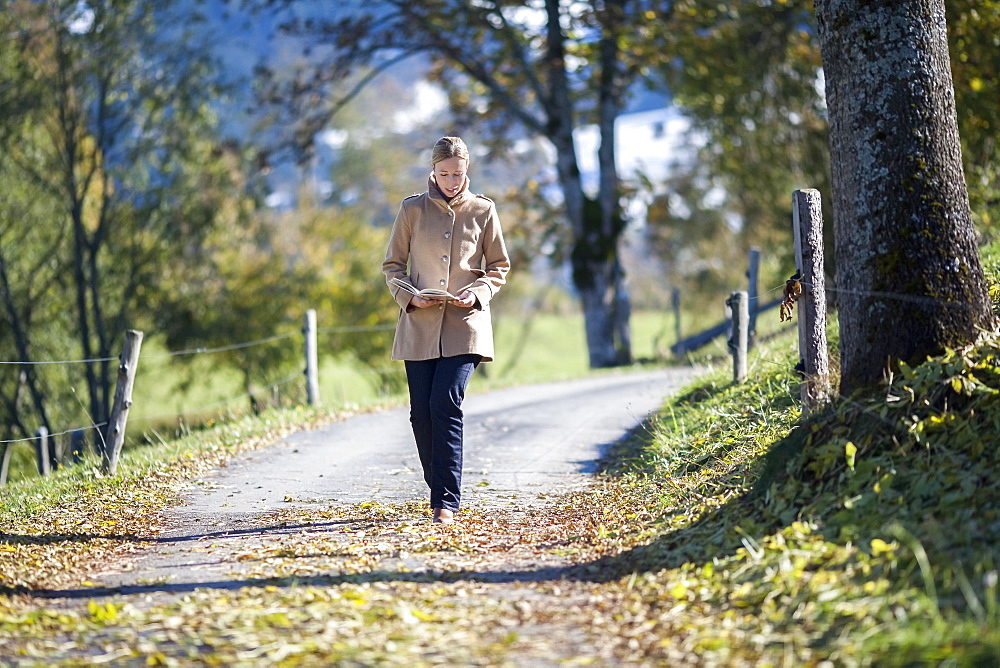 Austria, Salzburger Land, Maria Alm, Mature woman walking on autumn alley