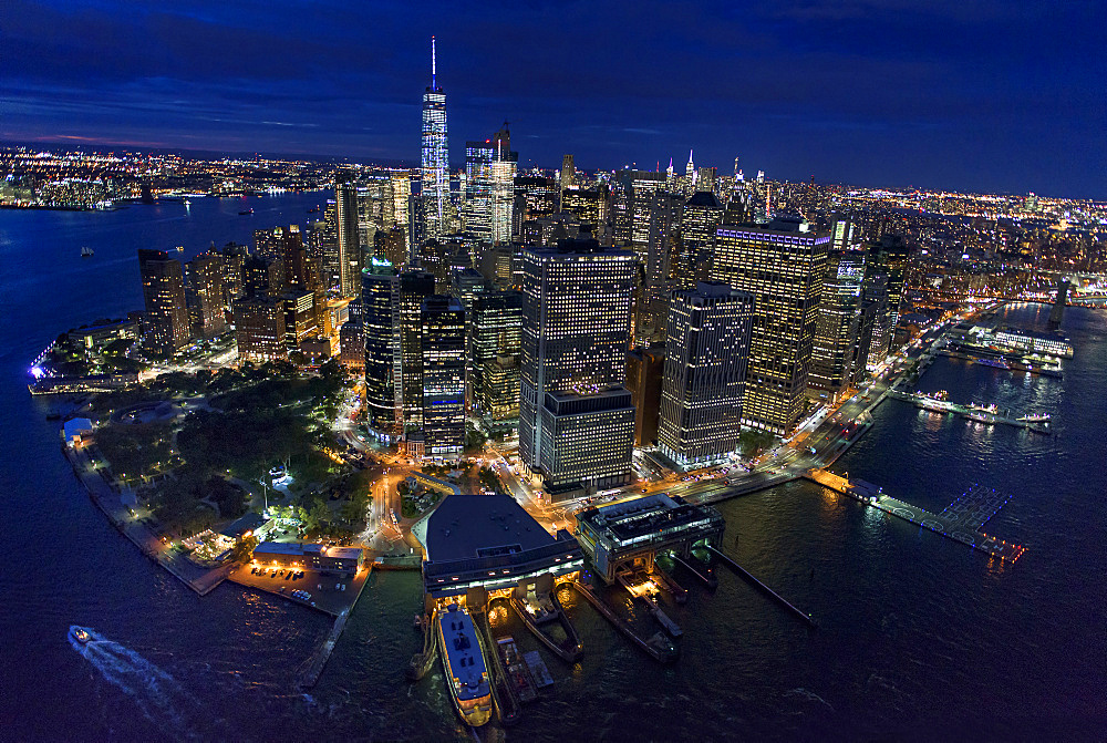 USA, New York, New York City, Manhattan, Aerial view of illuminated skyline with harbor at night