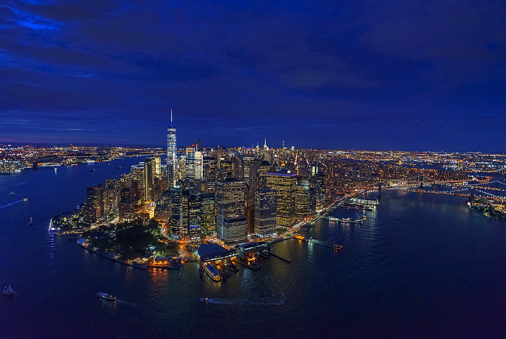USA, New York, New York City, Manhattan, Aerial view of illuminated skyline with harbor at night
