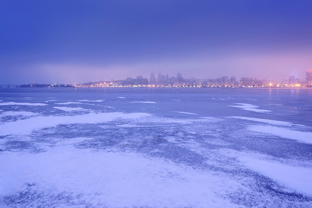 Ukraine, Dnepropetrovsk region, Dnepropetrovsk city, Dramatic sky over frozen river at dusk