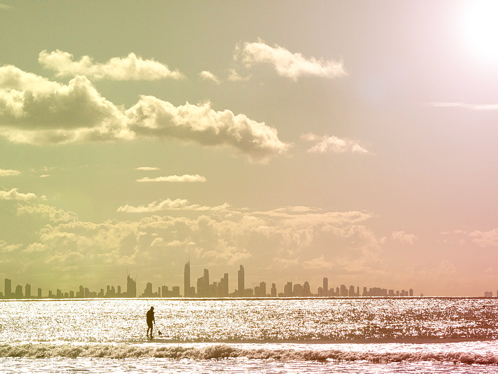 Silhouette of man paddleboarding on sea at sunset, Gold Coast, Australia