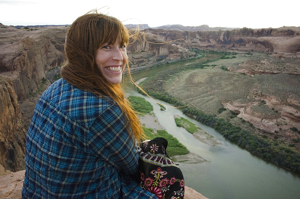 Smiling woman sitting at the Grand Canyon, Grand Canyon, Arizona, USA
