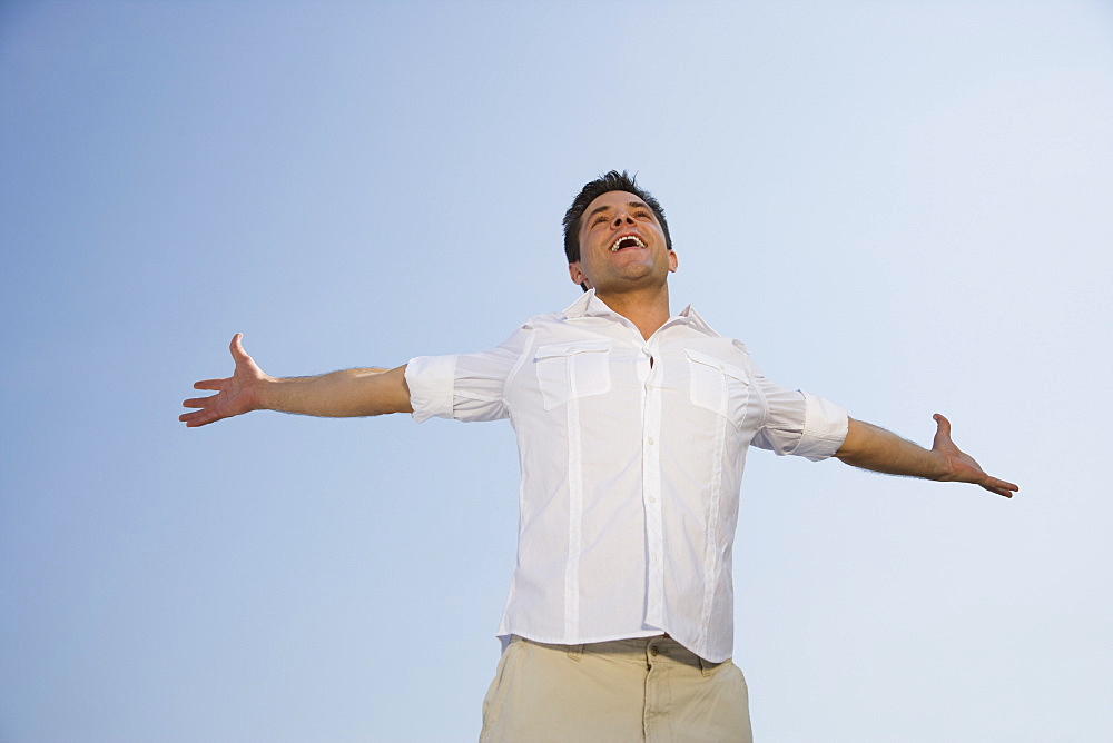 Low angle view of man with arms outstretched