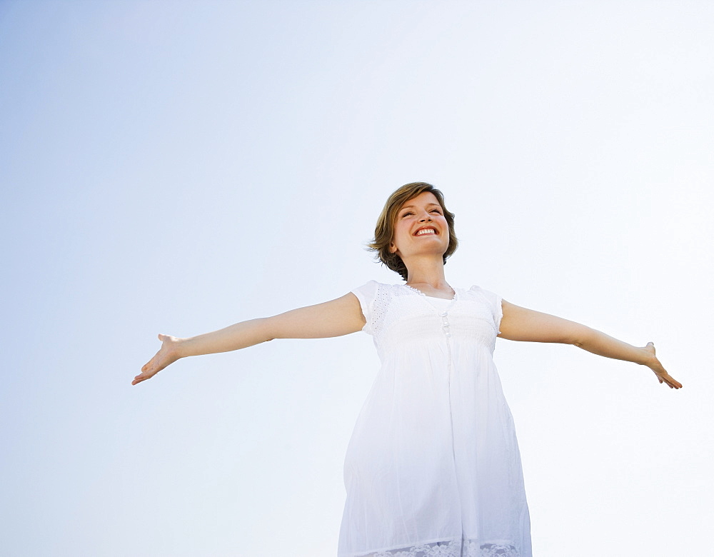 Low angle view of woman with arms outstretched