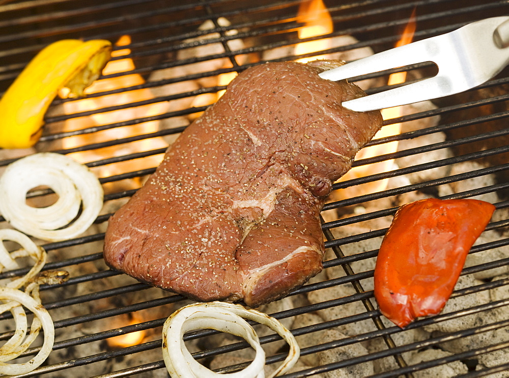 Steak and vegetables cooking on grill