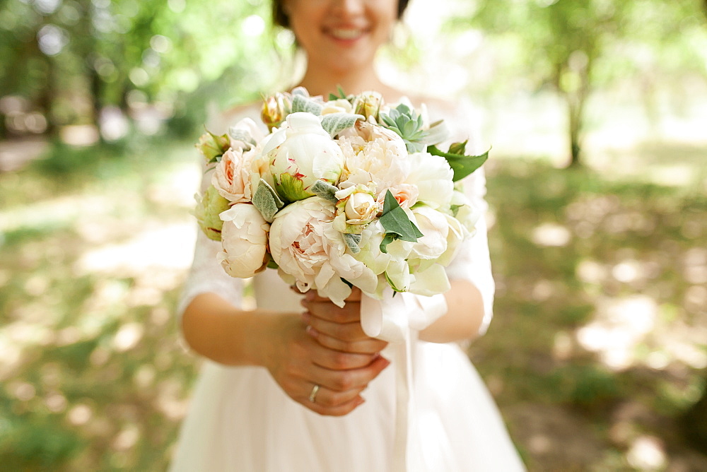 Bride holding bouquet of roses