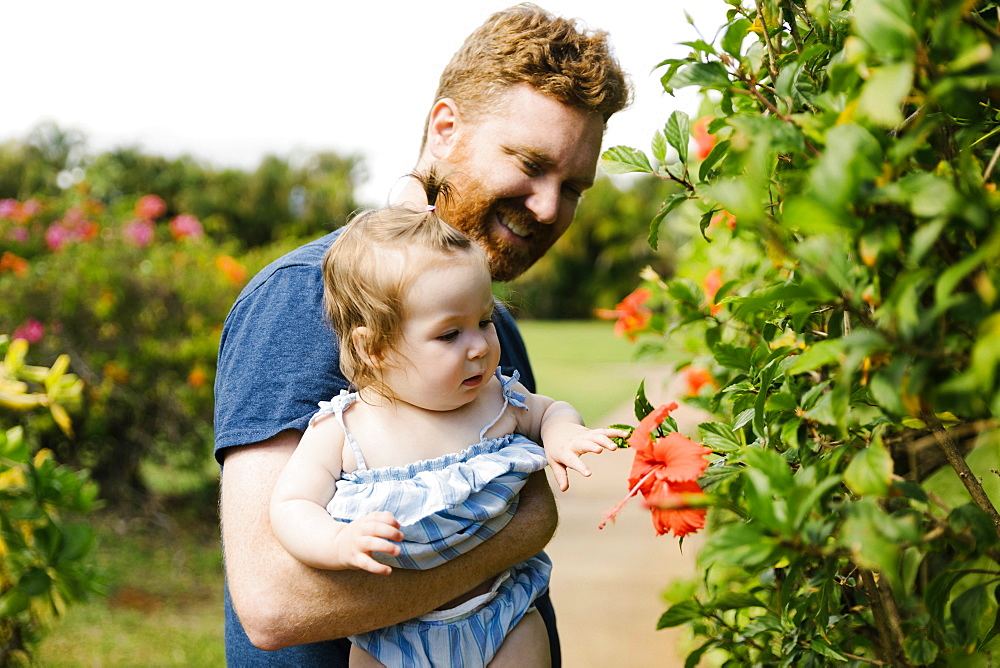 Man showing baby daughter flowers