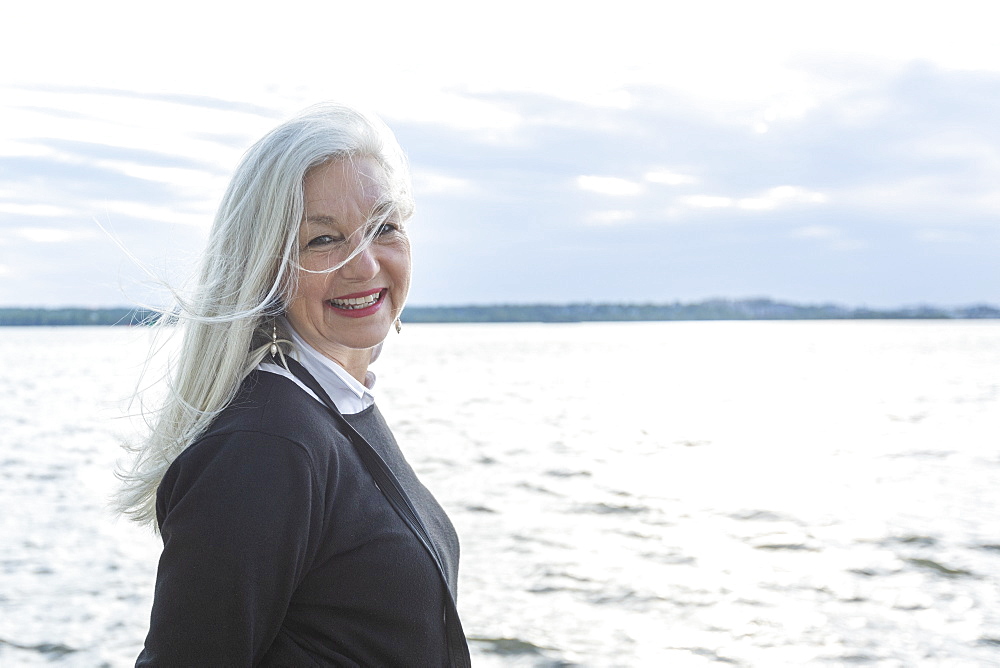 Smiling mature woman by Potomac River in Washington DC, USA