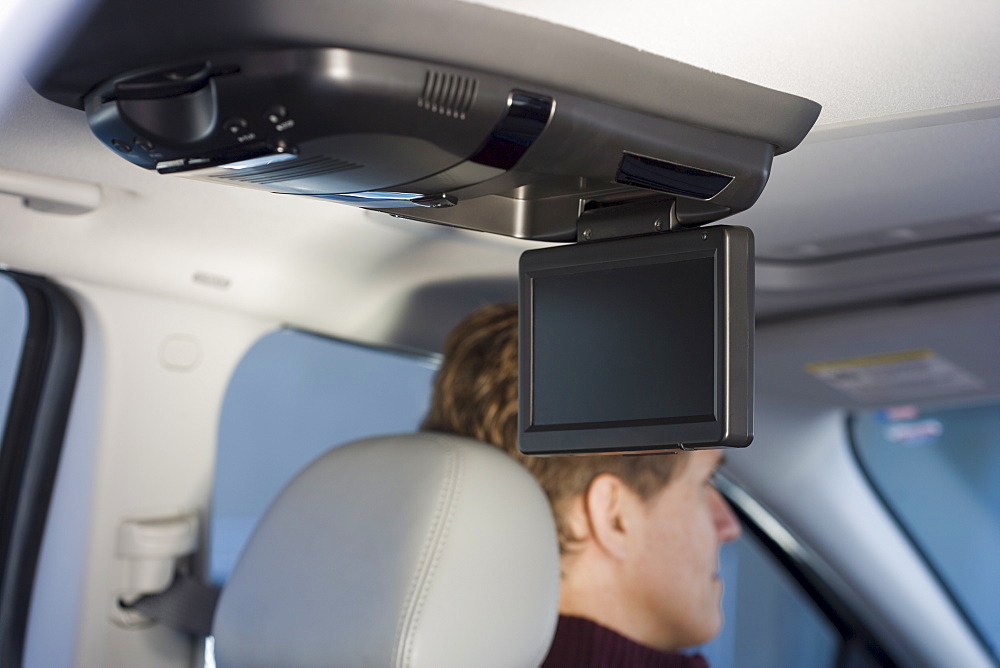 Television screen in car with man driving