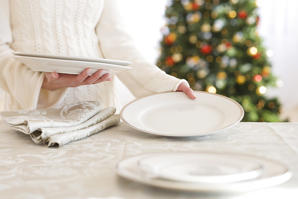 Woman setting table at Christmas