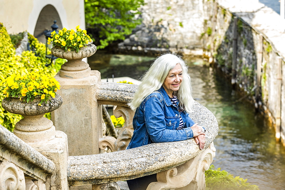 Woman on balcony of Villa del Balbianello by Lake Como, Italy