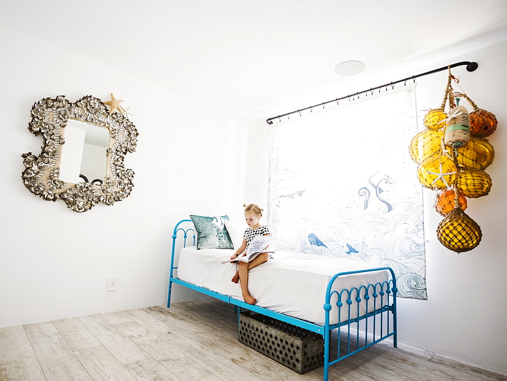 Girl reading book on bed