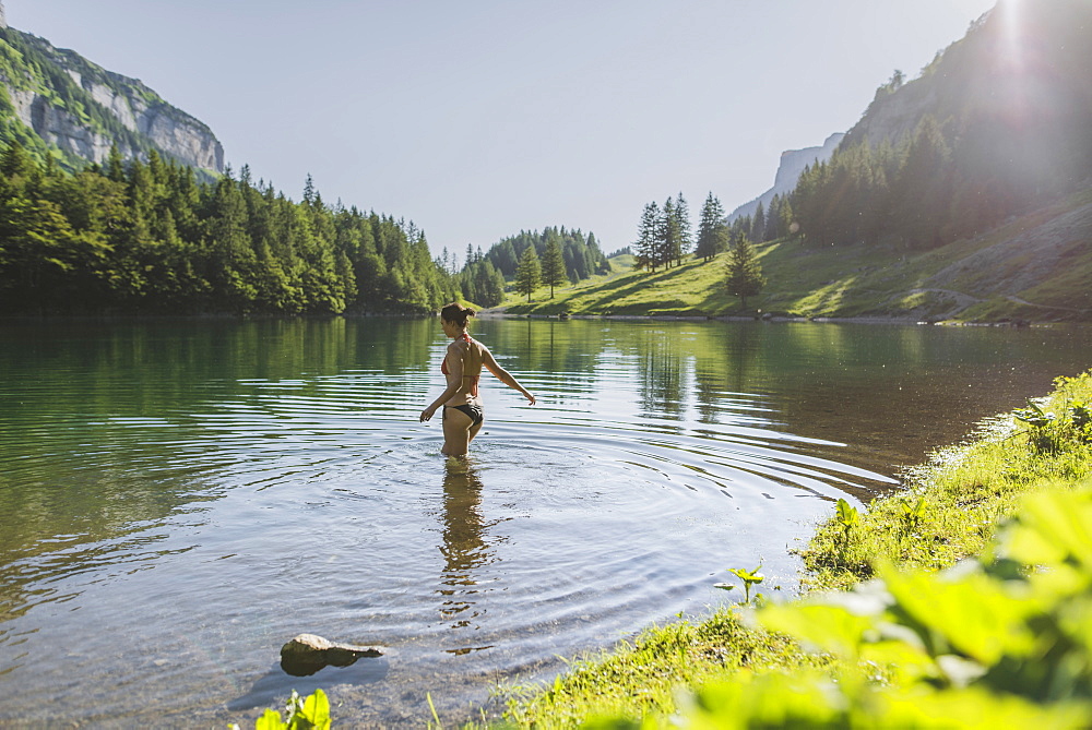 Woman swimming in Seealpsee lake in Appenzell Alps, Switzerland