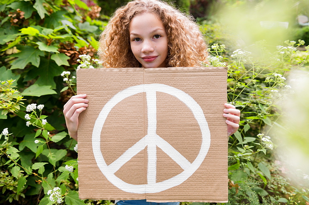 Girl holding sign with peace symbol