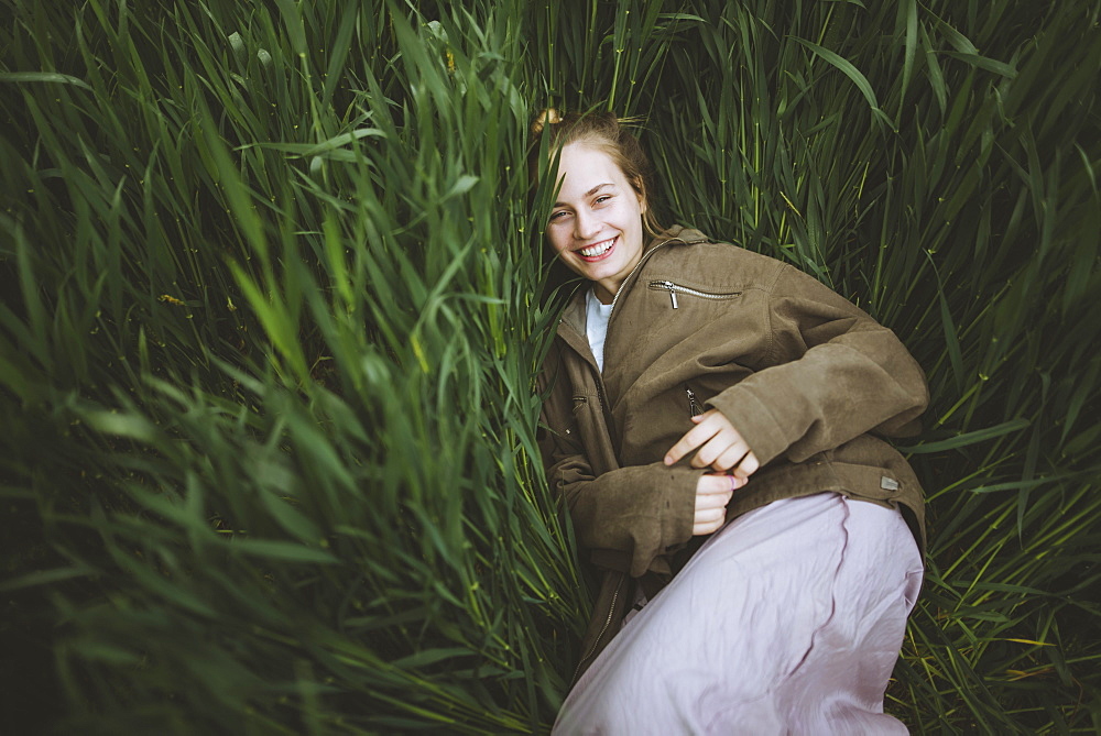 Smiling woman lying down in grass