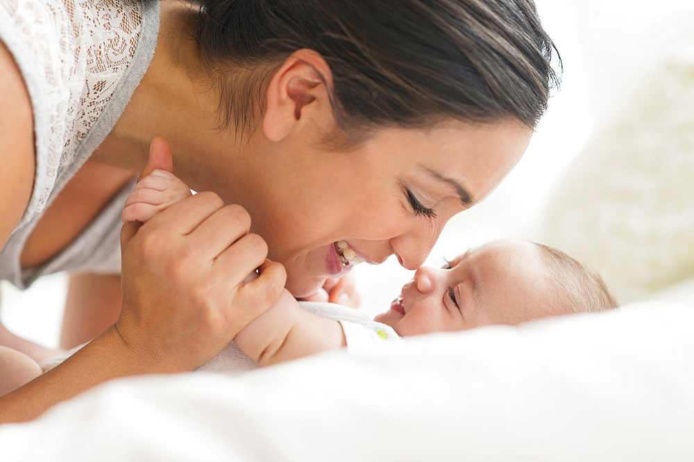 Smiling woman holding baby's hand