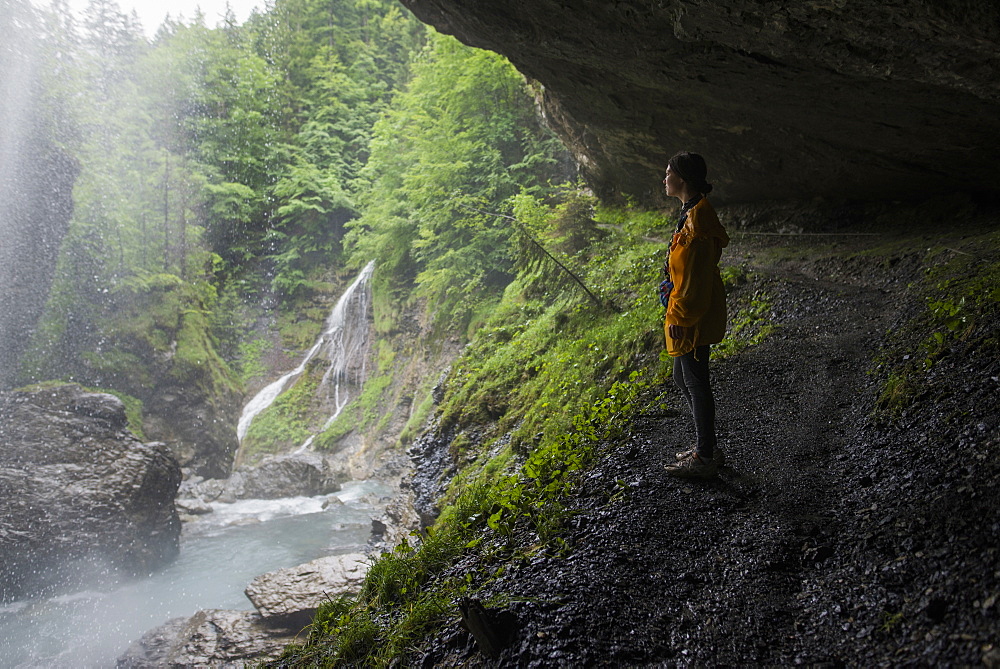 Woman in jacket by waterfall