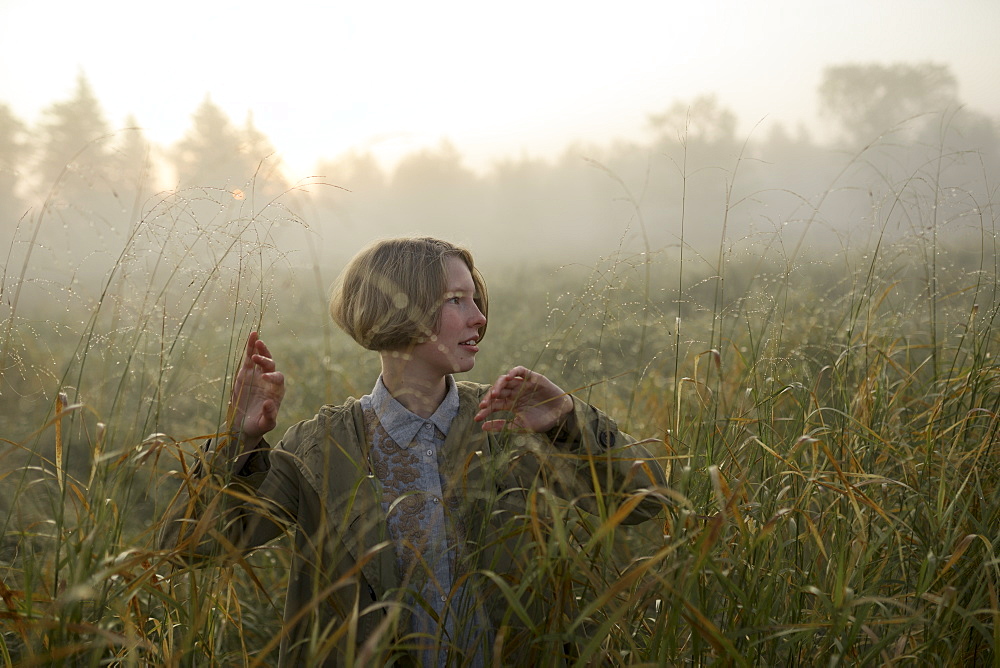 Young woman in field of long grass
