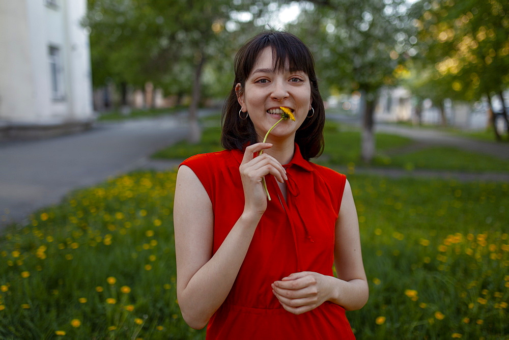 Smiling young woman holding flower