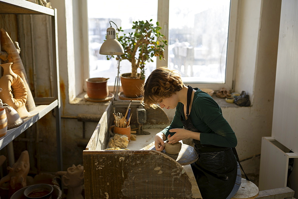 Potter working at desk in workshop