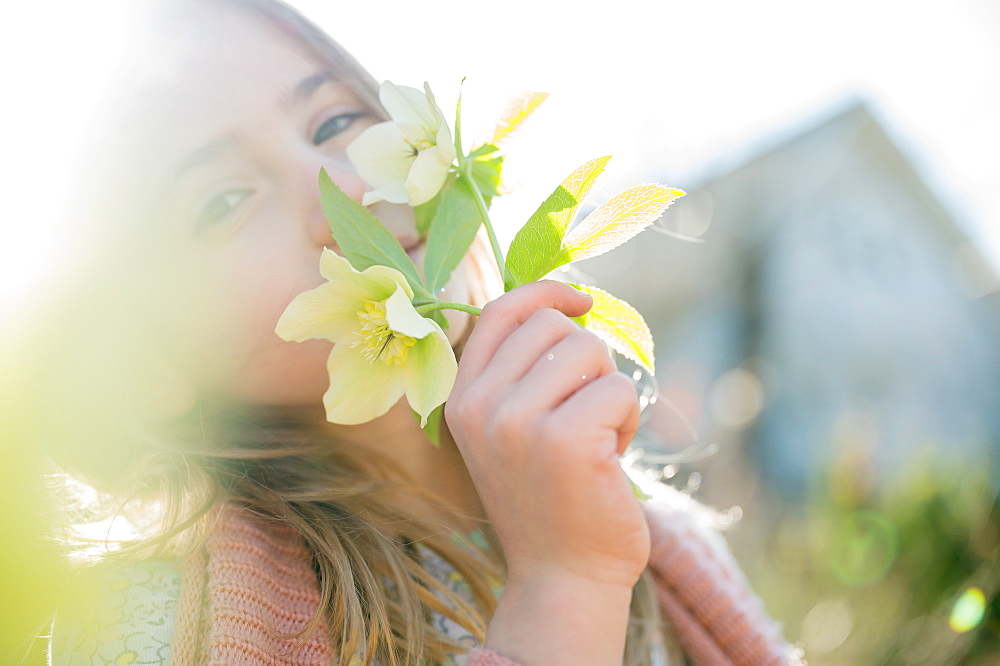 Portrait of girl smelling yellow flowers