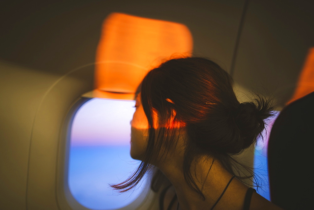 Portrait of young woman in plane illuminated with sunset light