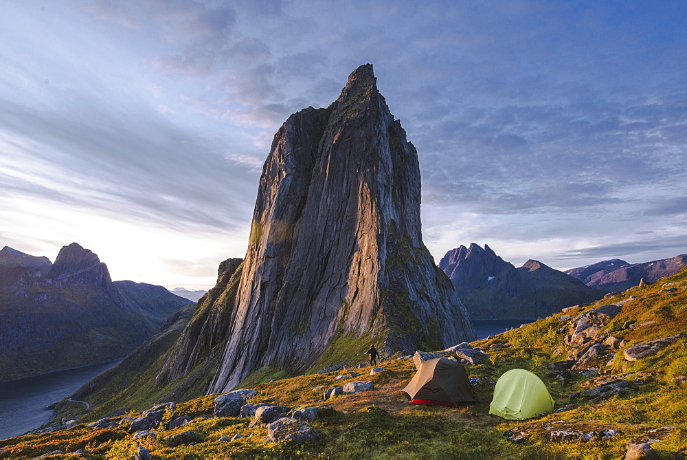 Norway, Senja, Man and two tents near Segla mountain at sunset