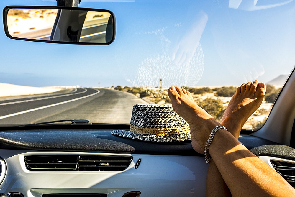 Female feet on dashboard during road trip