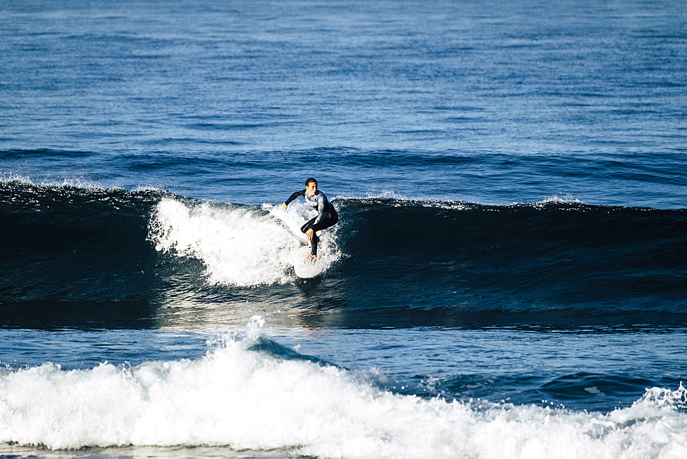 Teenage boy surfing waves