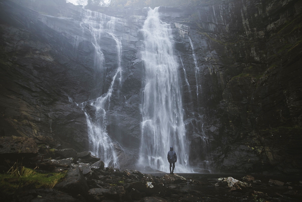 Man standing by Skjervefossen waterfall in Norway