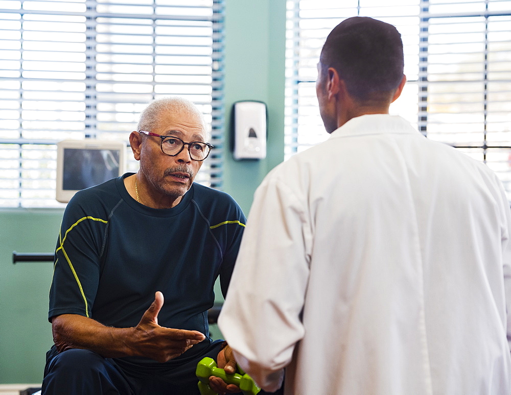 Senior man talking to doctor at rehabilitation center