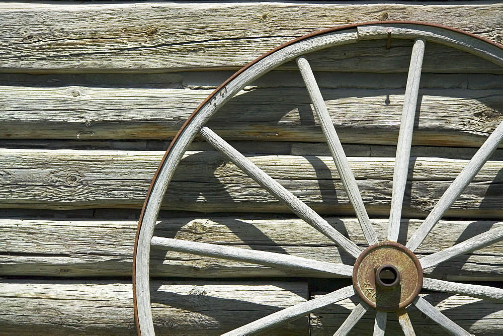 Wagon wheel against wooden wall