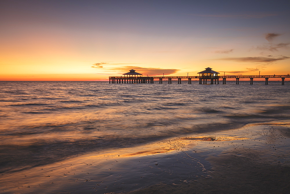 USA, Florida, Fort Myers Beach, Pier in sea at sunset