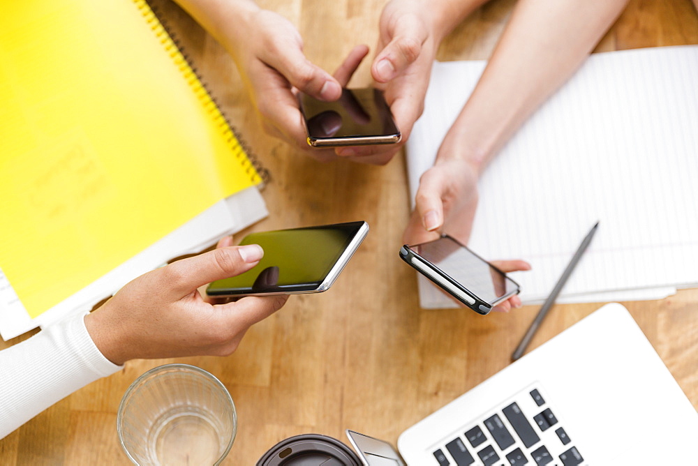 Coworkers using smart phones together