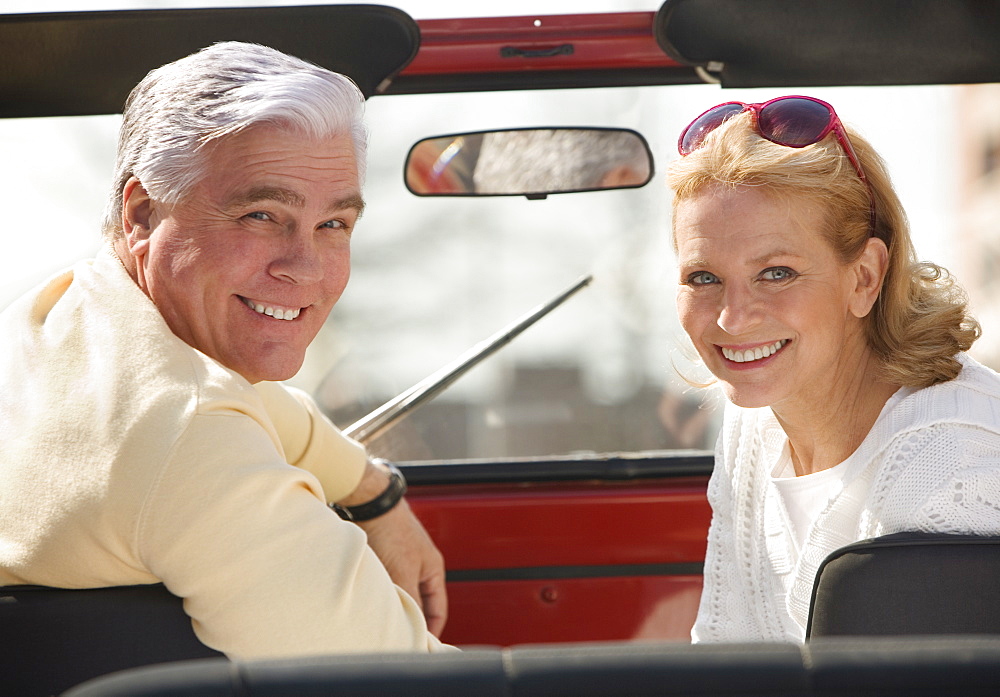 Senior couple sitting in jeep