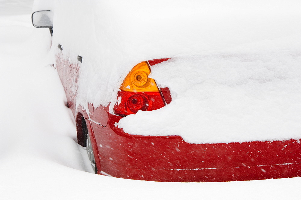 Car buried in snow in winter