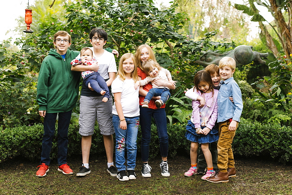 USA, California, Orange County, Group of children (12-17 months, 2-3, 6-7, 10-11, 12-13, 14-15) posing in garden