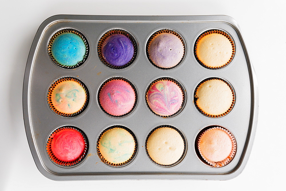 Colorful swirled cupcakes in pan