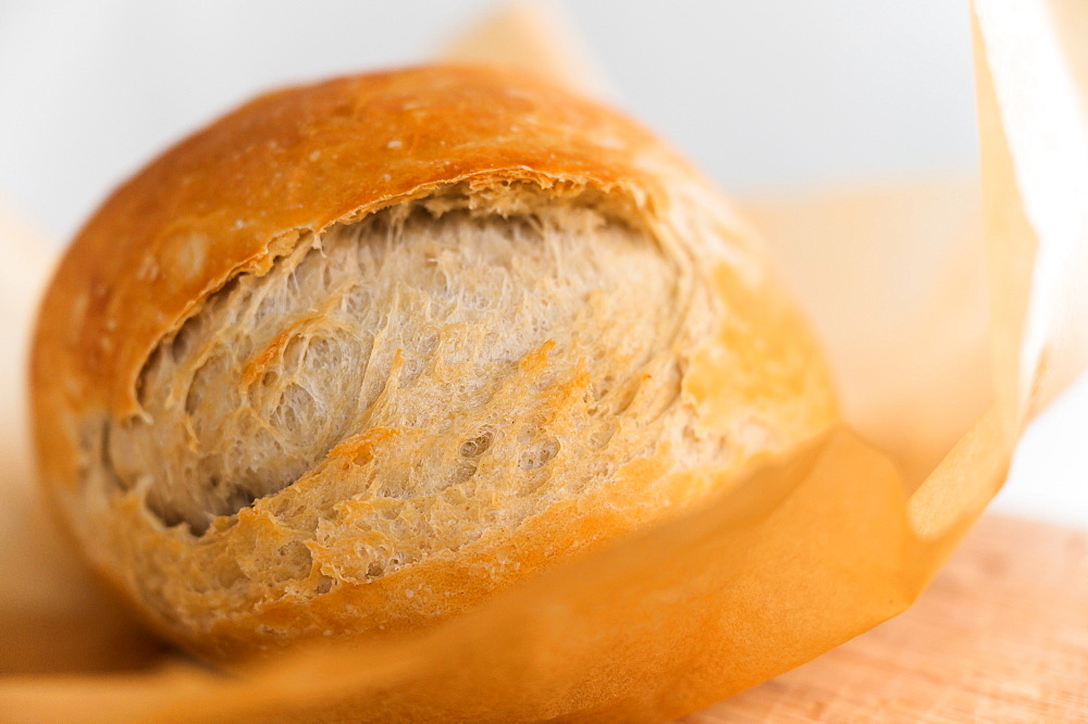 Fresh loaf of bread cooling on cutting board