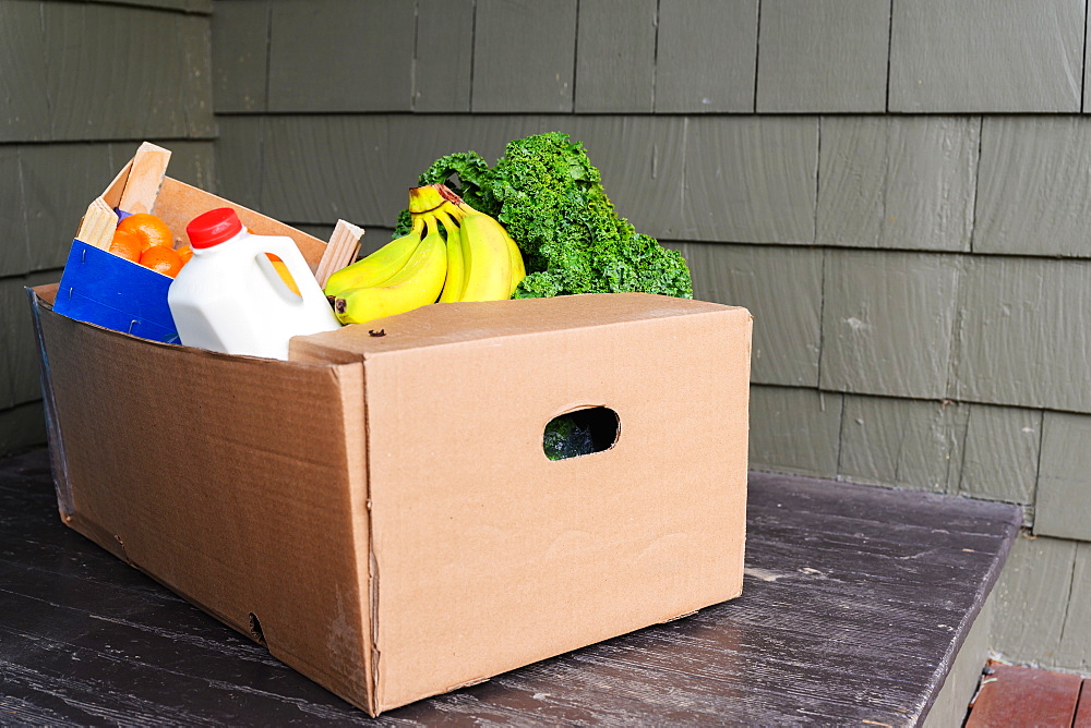 Box of delivered produce on house porch