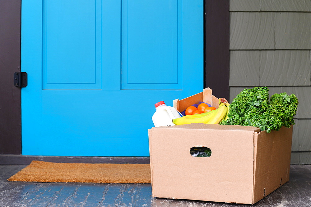 Box of delivered produce on house porch