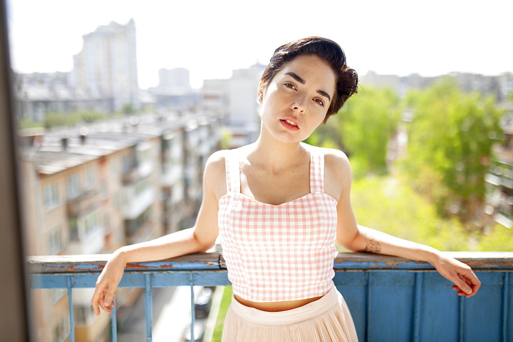 Russia, Novosibirsk, Portrait of young woman on balcony