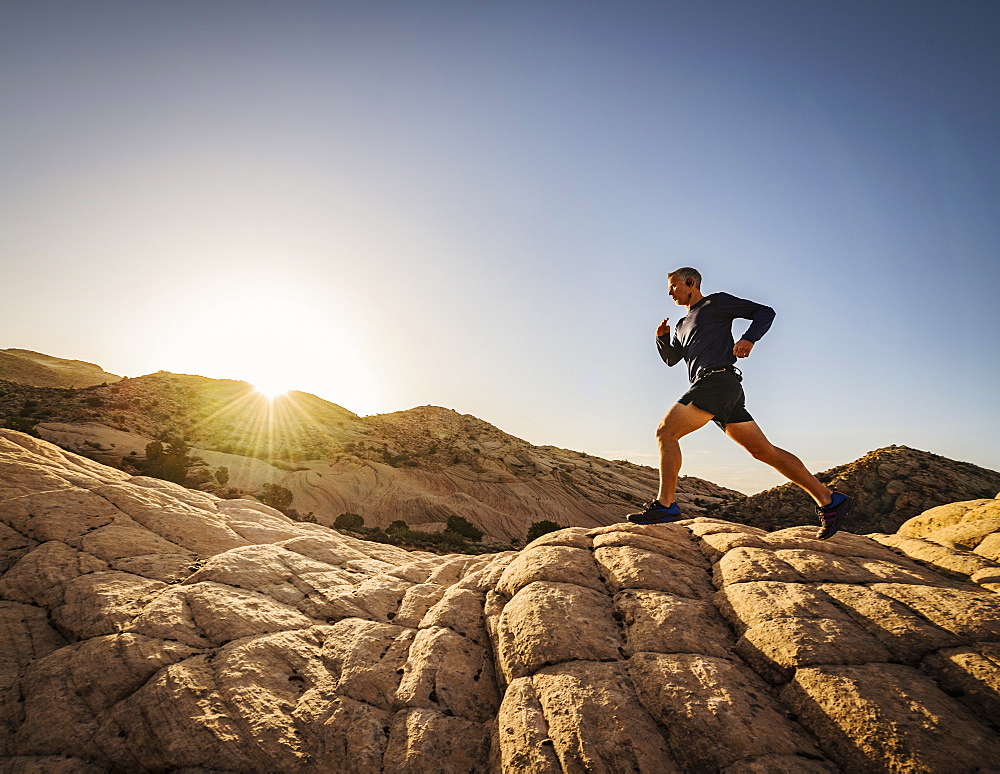 USA, Utah, St. George, Man running in rocky landscape