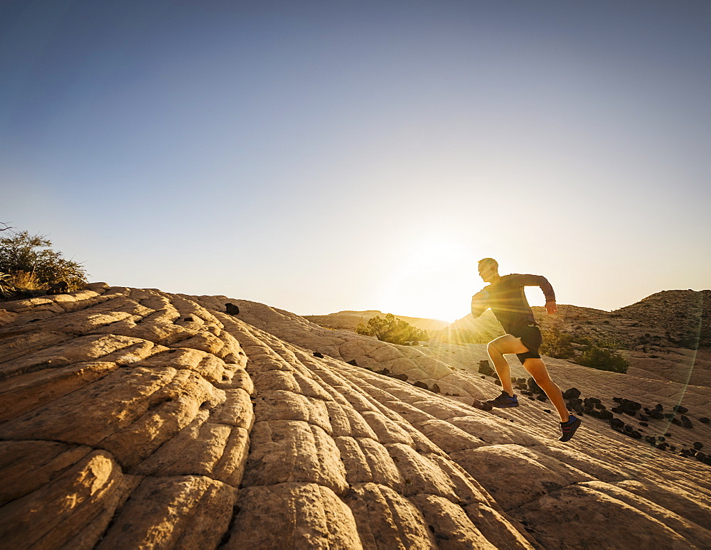 USA, Utah, St. George, Man running in rocky landscape